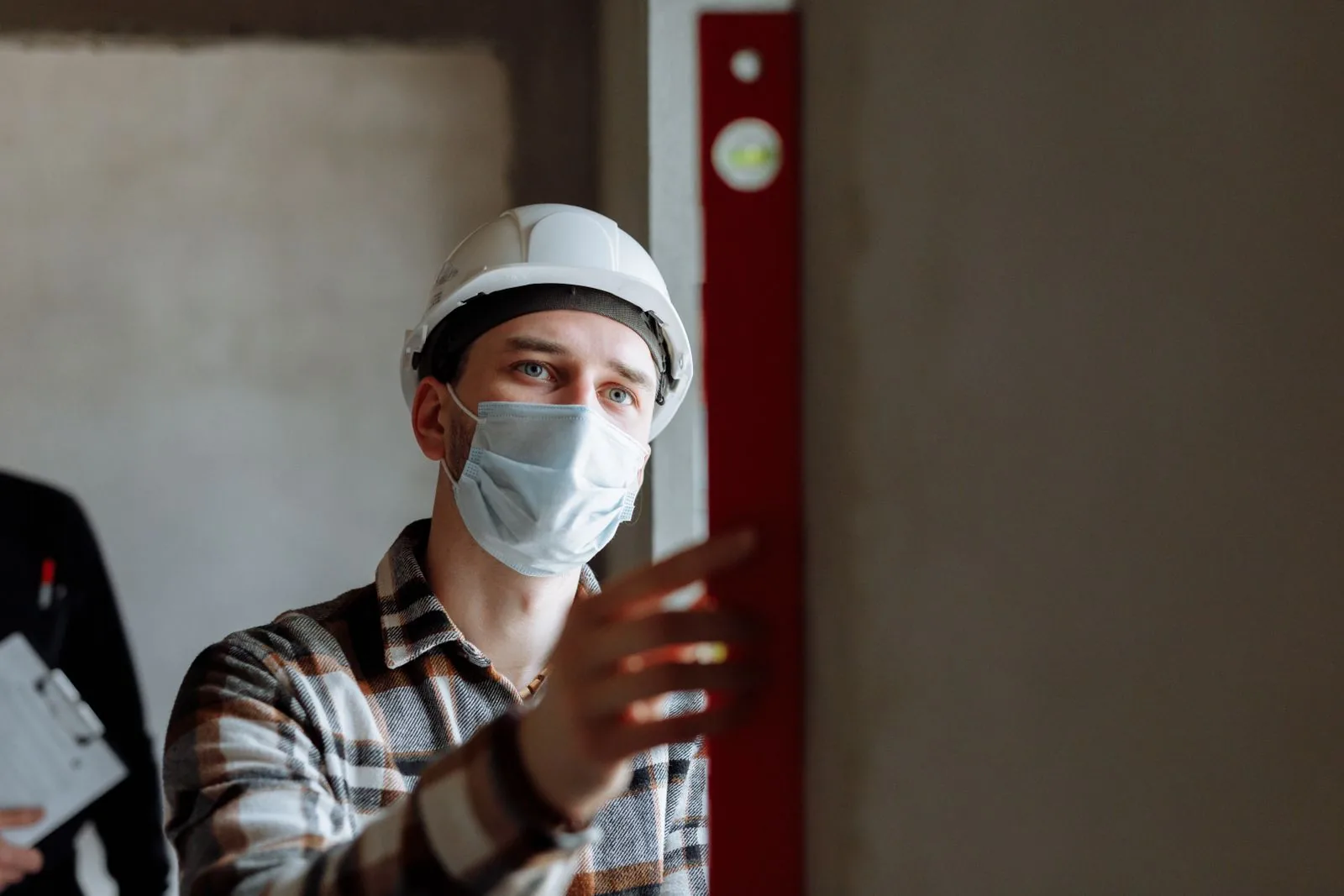 Professionista con casco protettivo durante un sopralluogo di sicurezza sul lavoro.